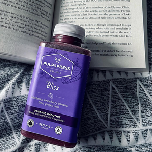 pulp & press blueberry smoothie with open book in background