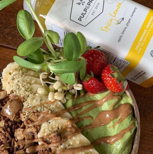 green smoothie bowl with strawberries and spicy lemon cold pressed juice