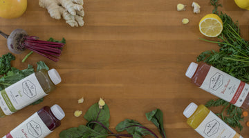 Pulp and press juices on a wooden table alongside fresh beets.