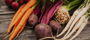 Beets, carrots and radishes on a wooden table.