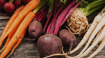 Beets, carrots and radishes on a wooden table.