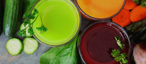 Top view of juice on a wooden table alongside vegetables.