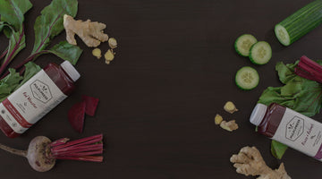 Pulp and press juices on a wooden table alongside fresh beets.