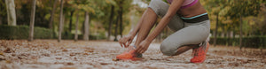 Woman tying shoe.
