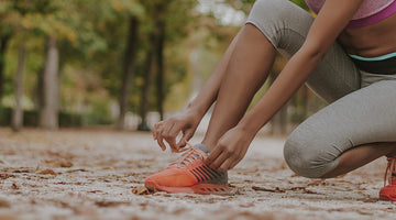 Woman tying shoe.