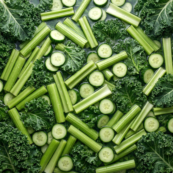 Green vegetables including cucumbers, celery, and kale arranged in a pattern.