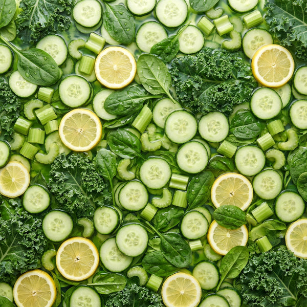 Assorted green vegetables and lemon slices arranged in a pattern.