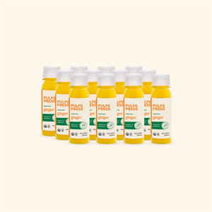 Multiple bottles of Pulp & Press organic ginger juice on a white background